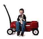 Boy with puppy and toy wagon