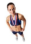 Woman athlete holding medal and making hand gesture