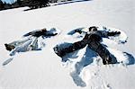 Couple making snow angels