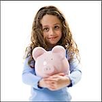 Young girl hugging piggy bank