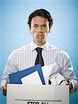 Portrait of a businessman holding a cardboard box full of belongings