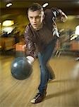 Young man bowling in a bowling alley