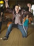 Young man jumping in excitement in a bowling alley