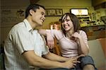 Flachwinkelansicht eines jungen Mannes sitzend mit ein junges Mädchen in eine Bowlingbahn