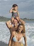 Portrait d'un homme et une femme avec leur fille sur la plage