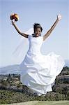 Portrait of a bride holding a bouquet of flowers and jumping