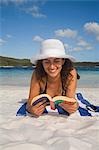 Une femme se détend sur la plage de sable blanc du lac McKenzie - un endroit populaire pour la baignade sur l'île de Fraser World Heritage Listed.