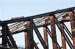 A group of climbers scale the steel suspension arch of the Sydney Harbour Bridge