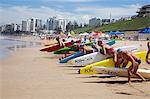 Competitors line up for the start of a rescue board race on Cronulla Beach. The lifesavers in their respective club colours are competing in the New South Wales Life Saving Championships.