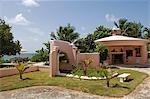 The garden at Little Whale House is enclosed by low pink stuco walls,with a fountain and outside fireplace,Little Whale Cay