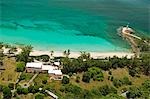 Vue aérienne de la petite maison de la baleine avec la plage et du phare derrière Little Whale Cay