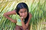 Village jeune fille assise sur lit de cultures récemment coupés dans le Village de Jamaraqua, regardant le monde passer. Communauté de Jamaraqua, région d'Amazonie, Brésil