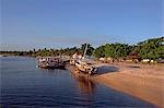 Brésil, Bahia, Barra de Serinhaem. Bateaux de pêche, établis sur la plage devant le village au coucher du soleil.