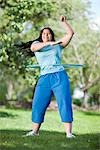 young plump girl doing hula hoop