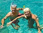 A senior couple swimming with snorkels