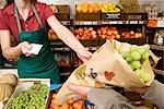 man paying shopkeeper for fruit