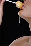 Woman holding honey lollipop to her lips