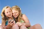 Two young girls sharing an ipod