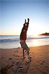 Frau macht einen Handstand auf dem Strand, Santa Cruz, Kalifornien, USA