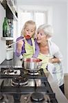 girl with grandmother cooking jam