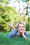 femme couché dans l'herbe souriant