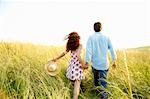 Couple holding hands in a wheat field