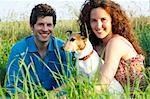 Couple with dog in a wheat field