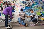 Adolescent gang faire des graffitis sur un mur