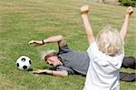 grand-père et enfants jouant au football