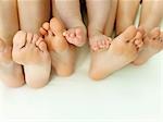 A row of bare feet on a white sheet