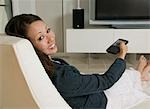 Woman reclining in living room Watching Television, portrait