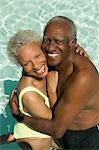 Senior Couple hugging in swimming pool, elevated view portrait.