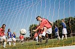 Girl (13-17) scoring with soccer ball