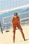 Joueuse de volley-ball de plage femmes flexion vers le bas, la main sur les genoux, en attente pour servir