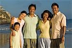 Family with girl (7-9) on beach, (portrait)