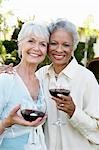 Middle-aged Friends standing outside, Drinking Wine from wineglasses