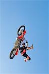 Freestyle motocross racer performing stunt in air