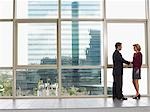 Businessman and woman shaking hands in office building