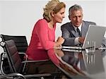 Business colleagues using laptop at conference table