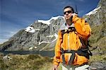 Hiker using walkie-talkie on mountain trail