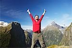 Woman with arms raised on top of mountain peak