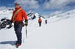 Drei Wanderer zusammen mit Sicherheit-Linie in verschneiten Bergen