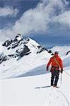 Wanderer, die mit Sicherheit-Linie in den schneebedeckten Bergen, Rückansicht verbunden