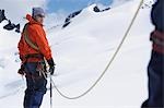 Wanderer, die zusammen mit Sicherheit-Linie in verschneiten Bergen
