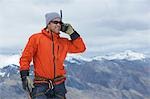 Hiker using walkie-talkie on mountain peak