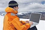 Wanderer mit Laptop auf verschneite Berggipfel