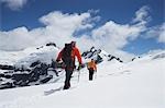 Wanderer, die zusammen mit Sicherheit-Linie in den schneebedeckten Bergen, Rückansicht