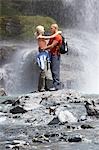 Couple embracing under spray of waterfall