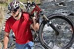 Cyclist carrying bike in river