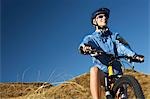 Woman sitting on bicycle in field